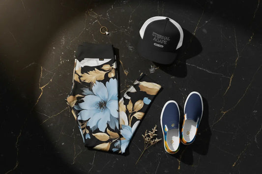 Eternal Agape luxury flat lay featuring White Sky Blue and Black Floral Yoga Leggings, Blue Abstract Canvas Shoes, and Eternal Agape 5 Panel Trucker Cap on black marble