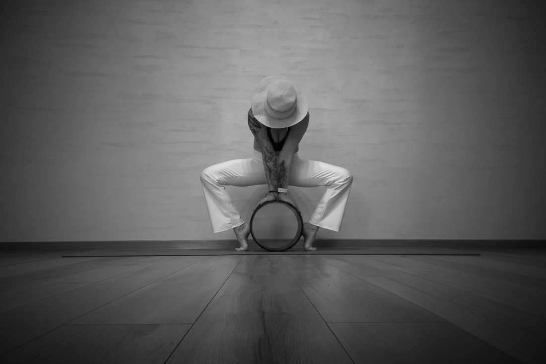 Kamala in a deep forward fold with a yoga wheel — Eternal Agape Community Spotlight